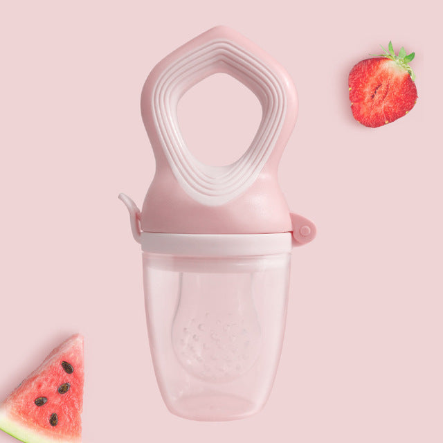 Een sfeerfoto van de fruitspeen in het roze die rechtop staat met het handvat wijzend naar boven. Naast de fruitspeen zijn een stuk aardbei en watermeloen te zien.
